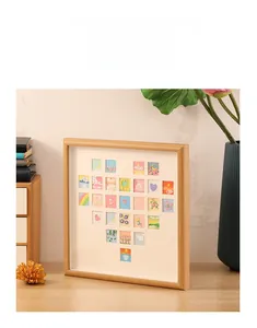 3D heart collage shadow box frame with miniature art tiles on a wooden desk