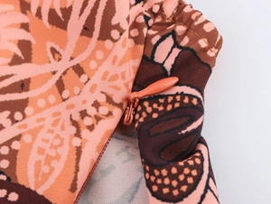 Detail of hidden side zipper on peach floral printed vacation set pants