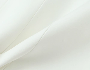 Close-up of white elastic fabric texture and soft pleats on a bow mini dress