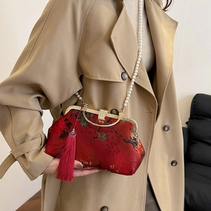 Retro Chinese style red floral handbag with pearl chain and tassel on model