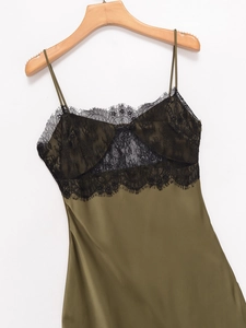 Détail de la robe en satin vert armée avec bordure en dentelle noire au décolleté