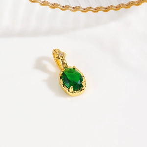 Detailed macro view of a 18k gold-plated turtle pendant with sparkling green zirconia