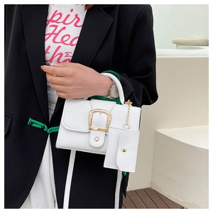 Close-up of white minimalist flap handbag with gold buckle and matching coin purse