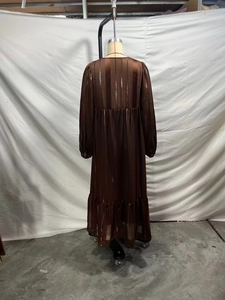 Détail du dos d'une robe longue marron avec texture verticale et ourlet à volants