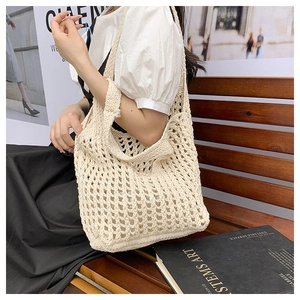 Detail of the knit texture and crochet weave on a beige summer beach tote bag