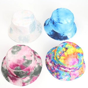 Detail view of four colorful tie-dye reversible bucket hats in cotton canvas fabric