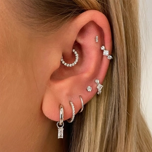 Detail of S925 sterling silver ear cuffs and CZ stud earrings worn on model's ear