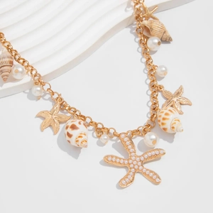Close-up of golden starfish and seashell pendants with white imitation pearls