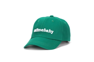 Dettaglio del cappellino verde con ricamo bianco call me baby su tessuto di twill cotone