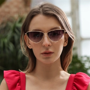 Primer plano de gafas de sol cat-eye con montura dorada y cristales morados degradados
