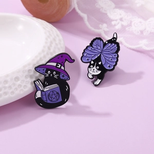Close-up of cute wizard cat and butterfly cat enamel pins with purple details