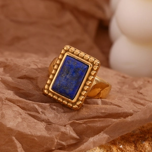 Detail of 18K gold-plated ring featuring rectangular lapis lazuli and gear-edge design