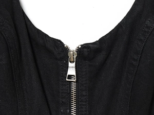 Detailed macro view of a silver metal zipper on a black denim sleeveless dress
