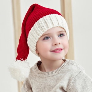 Enfant portant un bonnet de Noël rouge tricoté avec pompon blanc et bord côtelé