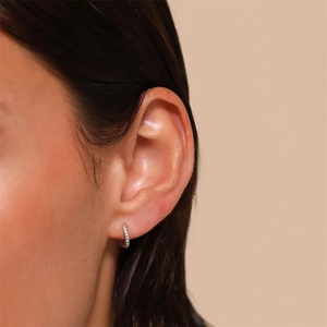 Macro view of S925 sterling silver hoop earrings with pave cubic zirconia on model ear