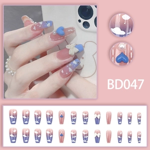 Detailed view of pink purple gradient press-on nails with 3D hearts and pearls