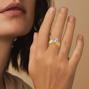 Gold plated stainless steel ring with 8mm frosted band and a blue zircon stone on model