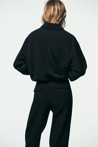 Vue arrière veste courte noire minimaliste zippée avec pantalon assorti pour femme