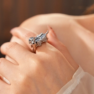 Detailed view of silver dog-shaped ring with inset diamonds on model's finger