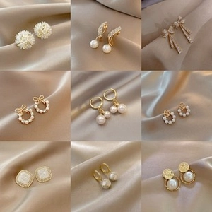 Elegant collection of butterfly tassel and pearl drop earrings on champagne satin