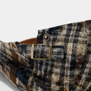Detail of vintage metal buckle and plaid wool fabric on tie-dye ivy newsboy cap