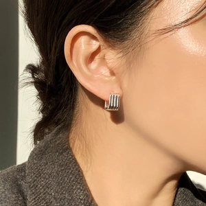Close-up of minimalist sterling silver C-shaped ribbed hoop earrings on female model