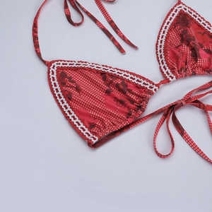Détail du haut de bikini rouge à vichy fleuri avec bordures en dentelle blanche
