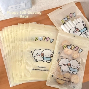 Cute cartoon puppy ziplock bags used for storing markers and small biscuits on a wooden table