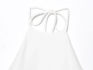 Detailed close-up of white halter neck mini dress with delicate bow tie drawstring closure