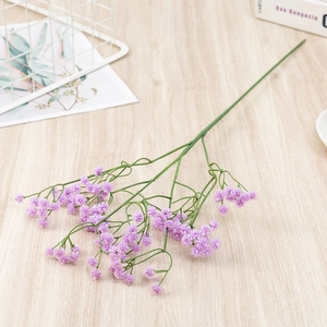 Close-up of purple artificial gypsophila flower bouquet on light wooden table