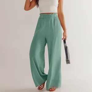 Dettaglio dei pantaloni larghi in cotone lino verde chiaro con vita alta elasticizzata