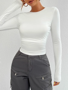 Detailed view of a white slim-fit long-sleeve knit top styled with grey cargo pants
