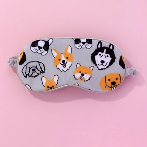 Detail showing the cute cartoon dog pattern on a soft plush sleep mask with elastic strap