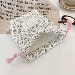 Floral quilted camera pouch with drawstring closure shown in a lifestyle scene