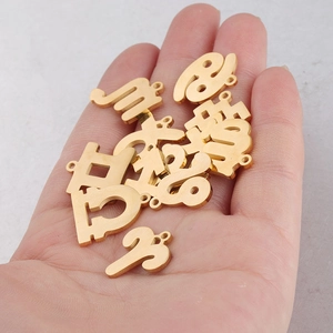 Golden 15mm stainless steel zodiac pendants shown on a palm for size reference