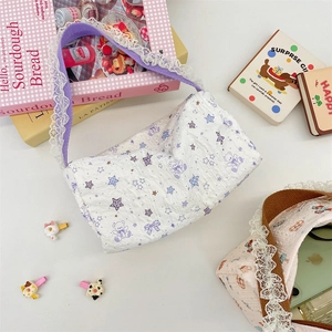 Quilted canvas bag detail with purple star pattern, lace strap and zipper closure