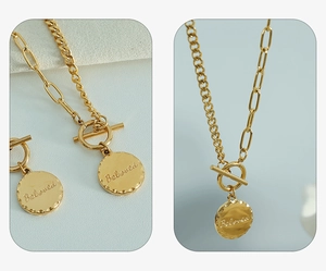 Detail view of gold OT buckle necklace with Beloved engraved disc and mixed chains