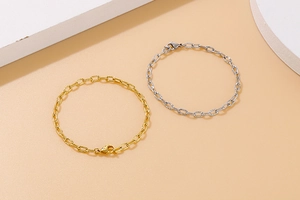 Detailed view of hammered gold and silver titanium steel chain bracelets with lobster clasps