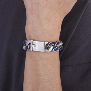 Nahaufnahme eines silber-blauen Panzerkettenarmbands am Handgelenk eines Models