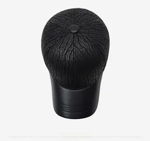 Top down view of black baseball cap showing embossed texture and leather brim detail
