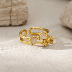 Detailed macro view of gold double-layer bow ring with opal hearts and sparkling crystals