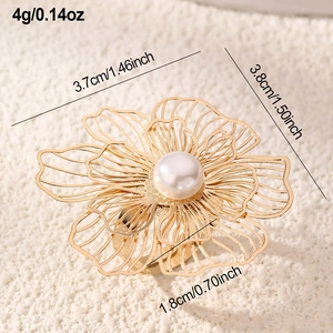 Macro detail of golden floral ring with brushed hollow petals and a large center pearl