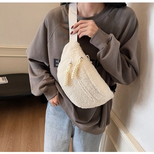 Close-up of white plush crossbody bag with soft faux fur texture and woven strap detail