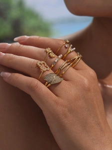 Close-up of gold ring set with sparkling 5A cubic zirconia and pearls on a hand