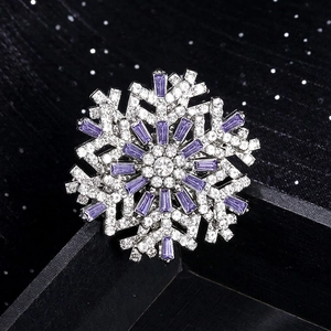 Rotating snowflake brooch with purple crystals and sparkling rhinestones in silver finish