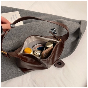 Macro view of brown leather hobo bag interior with pockets and adjustable strap