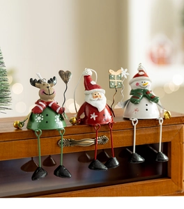 Three metal Christmas ornaments featuring Santa, elk, and snowman with hanging legs