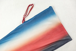 Detail of gradient mesh fabric with thin red straps and vibrant colorful knit texture