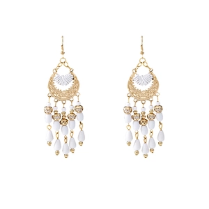 Detail of white beaded fringe tassels and golden frame on Bohemian drop earrings