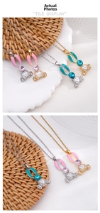Detail view of pink and blue enamel rabbit pendant with sparkling crystals and pearl